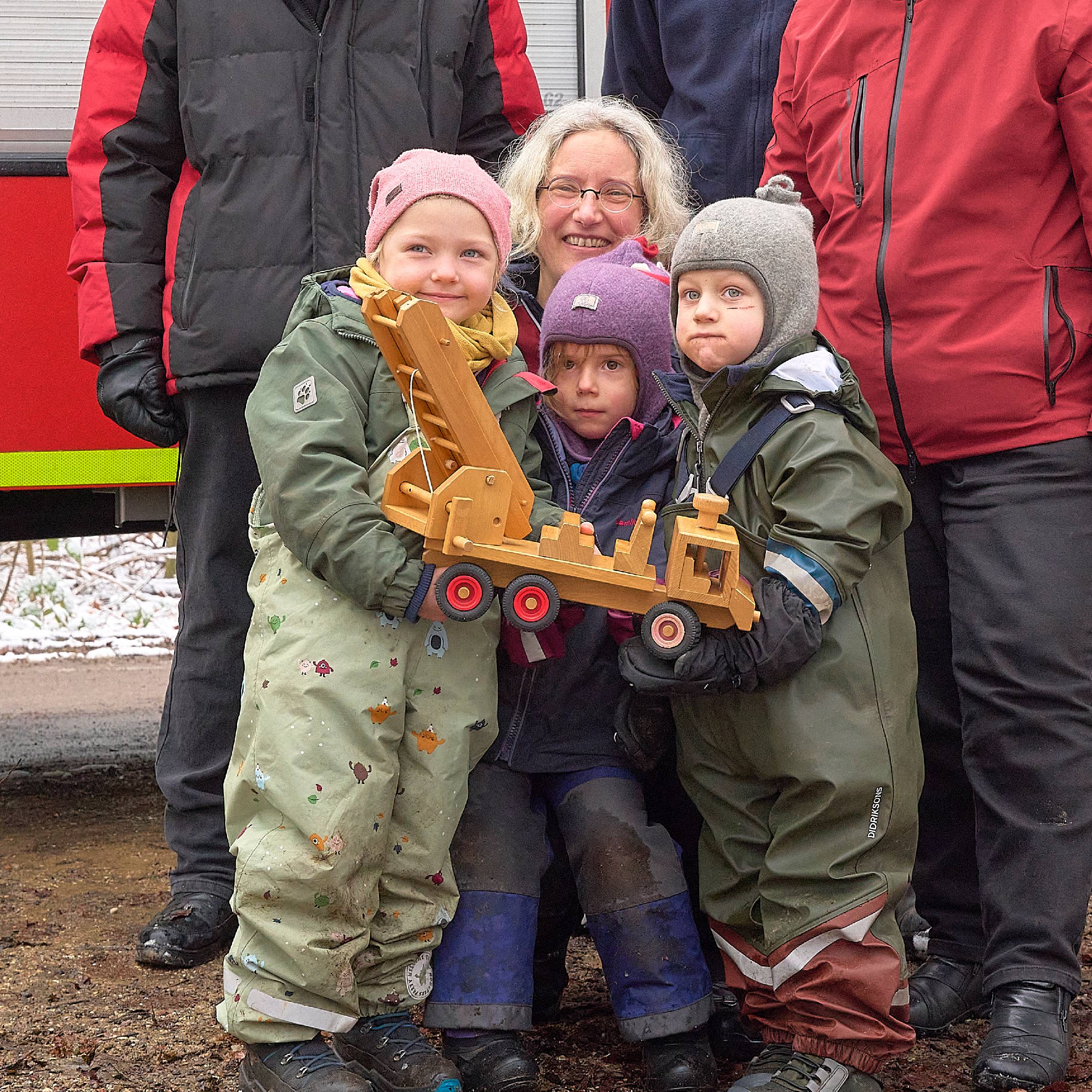 Das Feuerwehrauto in den Händen der Kinder