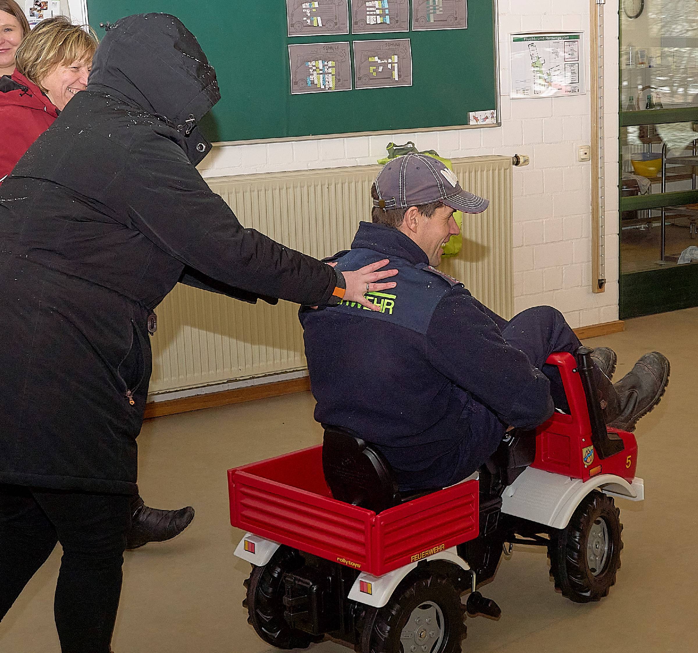 Feuerwehrmann auf einem Feuerwehrauto für Kinde